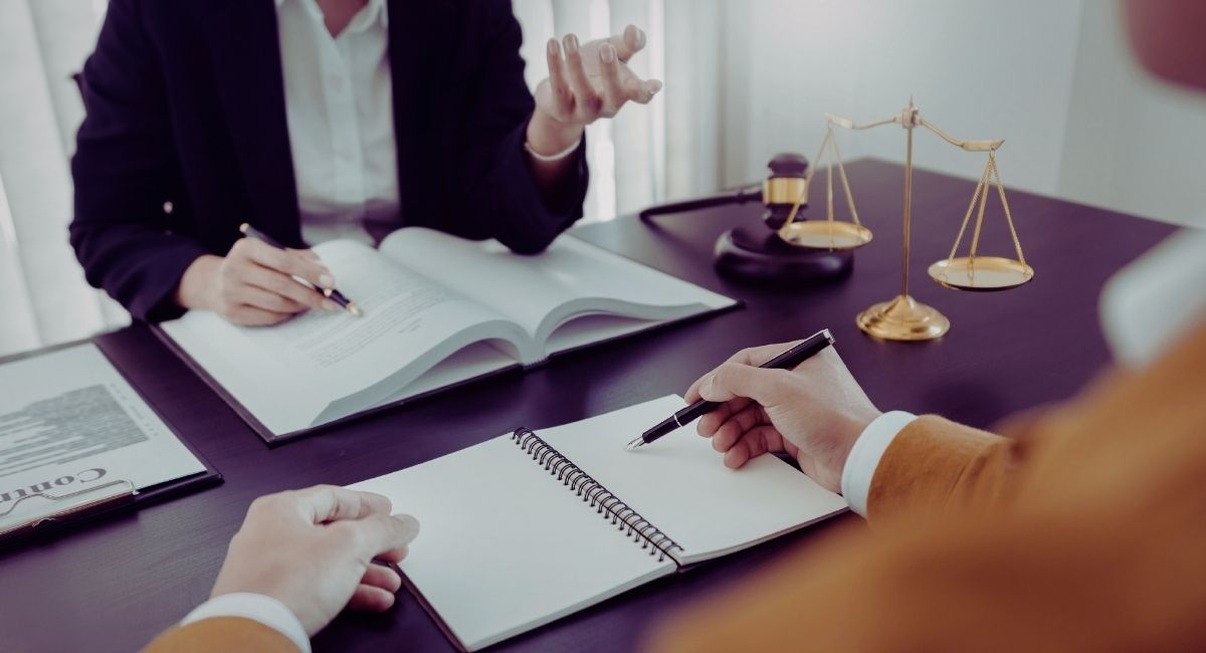 Avocat expliquant des documents juridiques à un client lors d'une consultation