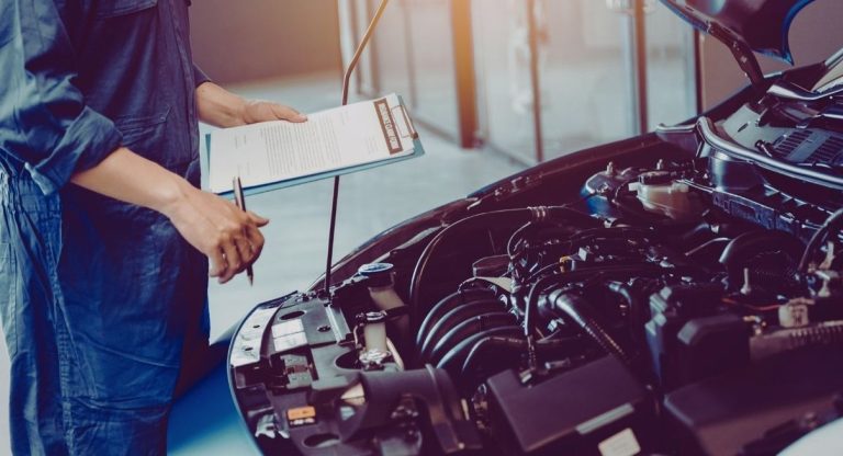 Mécanicien inspectant le moteur d'une voiture en garage