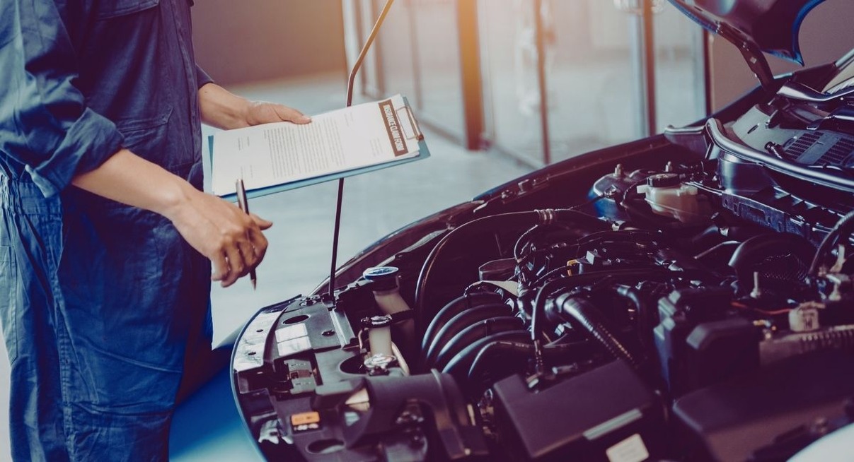 Mécanicien inspectant le moteur d'une voiture en garage