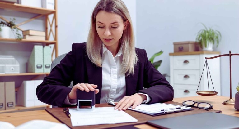 Notaire tamponnant un acte de succession sur son bureau
