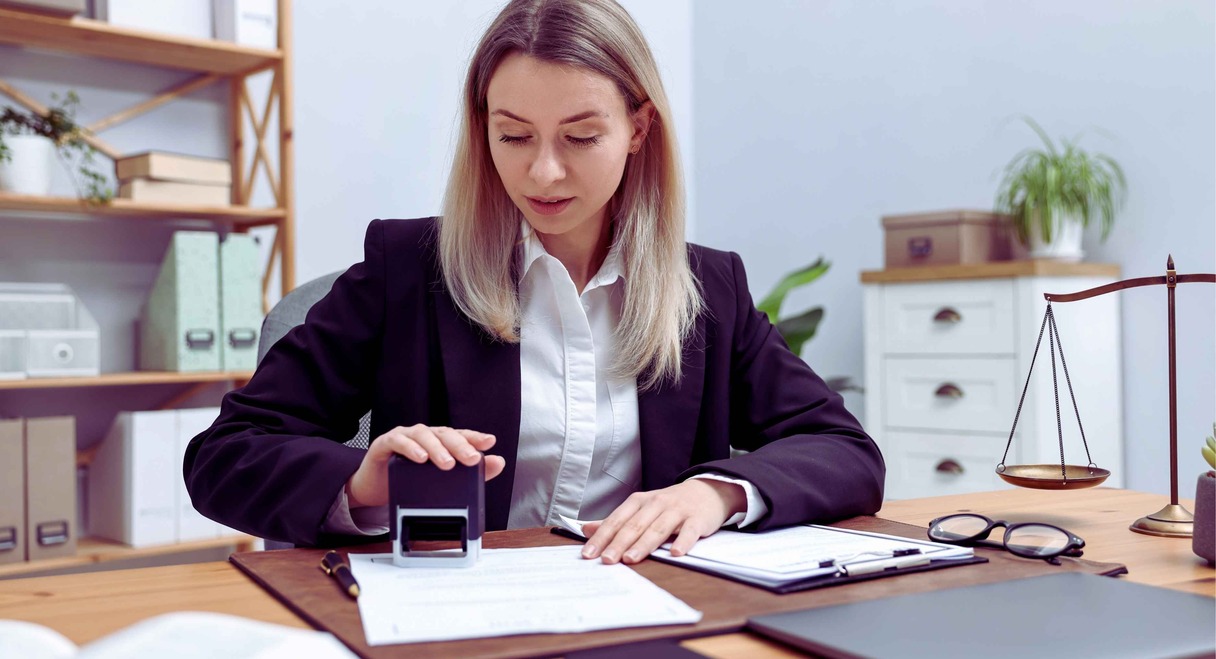 Notaire tamponnant un acte de succession sur son bureau
