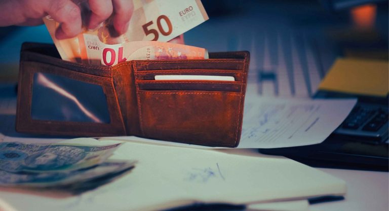 Portefeuille avec billets euros sur bureau