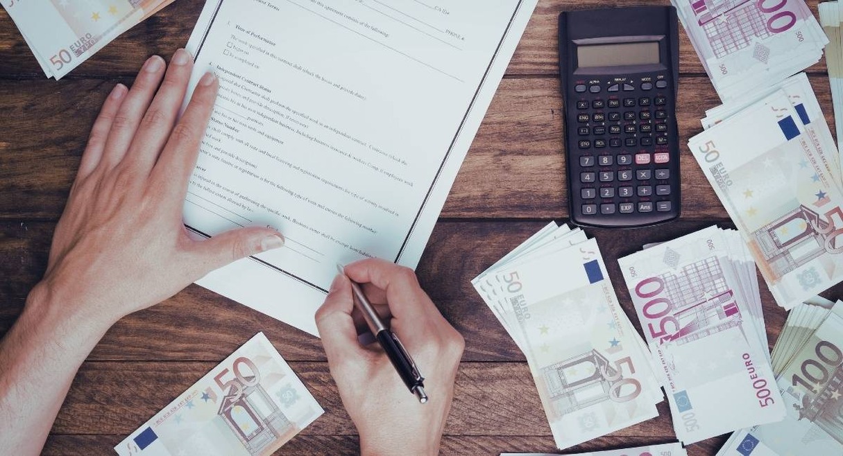 Comptage de billets euros sur table en bois avec calculatrice
