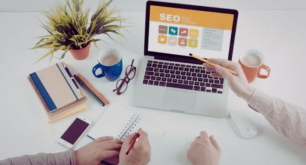 Personne planifiant une stratégie de marketing digital SEO sur un ordinateur portable