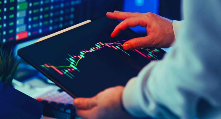 Trader analysant les tendances du marché boursier sur une tablette numérique