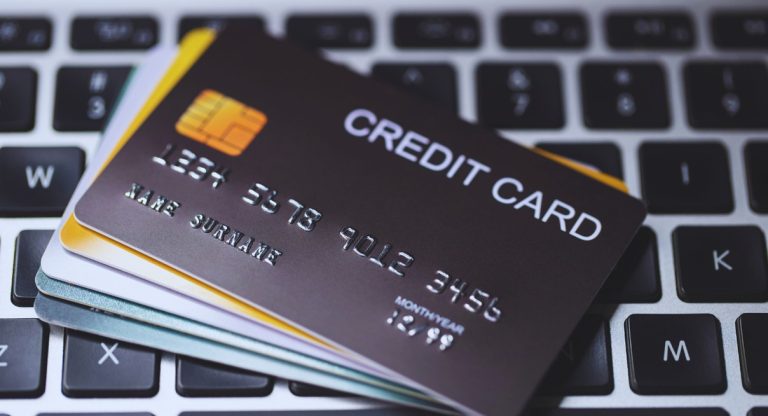 Pile de cartes bancaires posées sur un clavier d'ordinateur portable