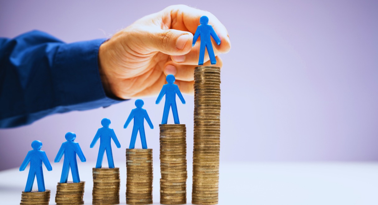Figurines bleues sur piles de pièces symbolisant une progression salariale