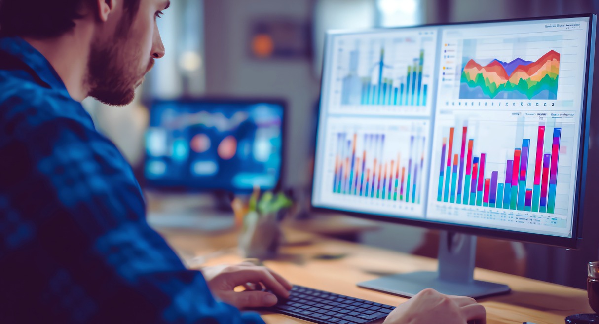Analyste devant un écran avec des graphiques et tableaux de bord KPI colorés