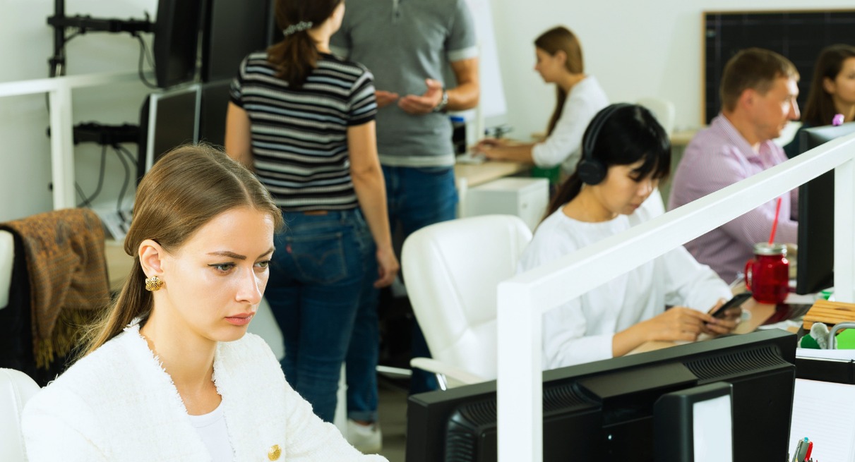 Employée sérieuse travaillant sur ordinateur dans un open space