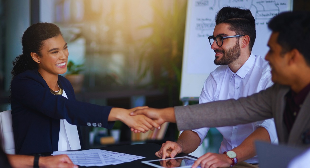 Poignée de mains entre professionnels en réunion pour améliorer la relation client