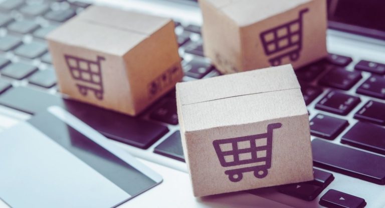 Mini cartons de livraison et carte bancaire posés sur un clavier d'ordinateur