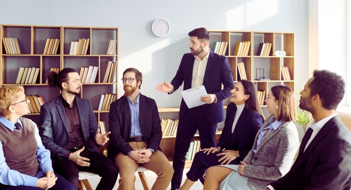 Un formateur anime une discussion de groupe assise en cercle dans un bureau