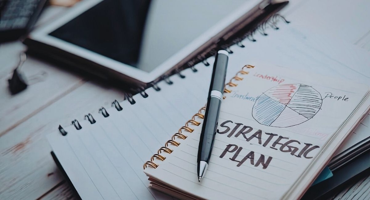 Carnet de notes avec plan stratégique manuscrit et diagramme sur un bureau