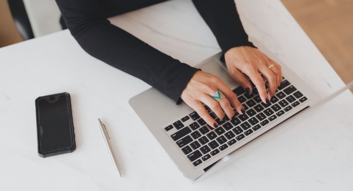 Mains tapant sur un ordinateur portable dans un bureau lumineux